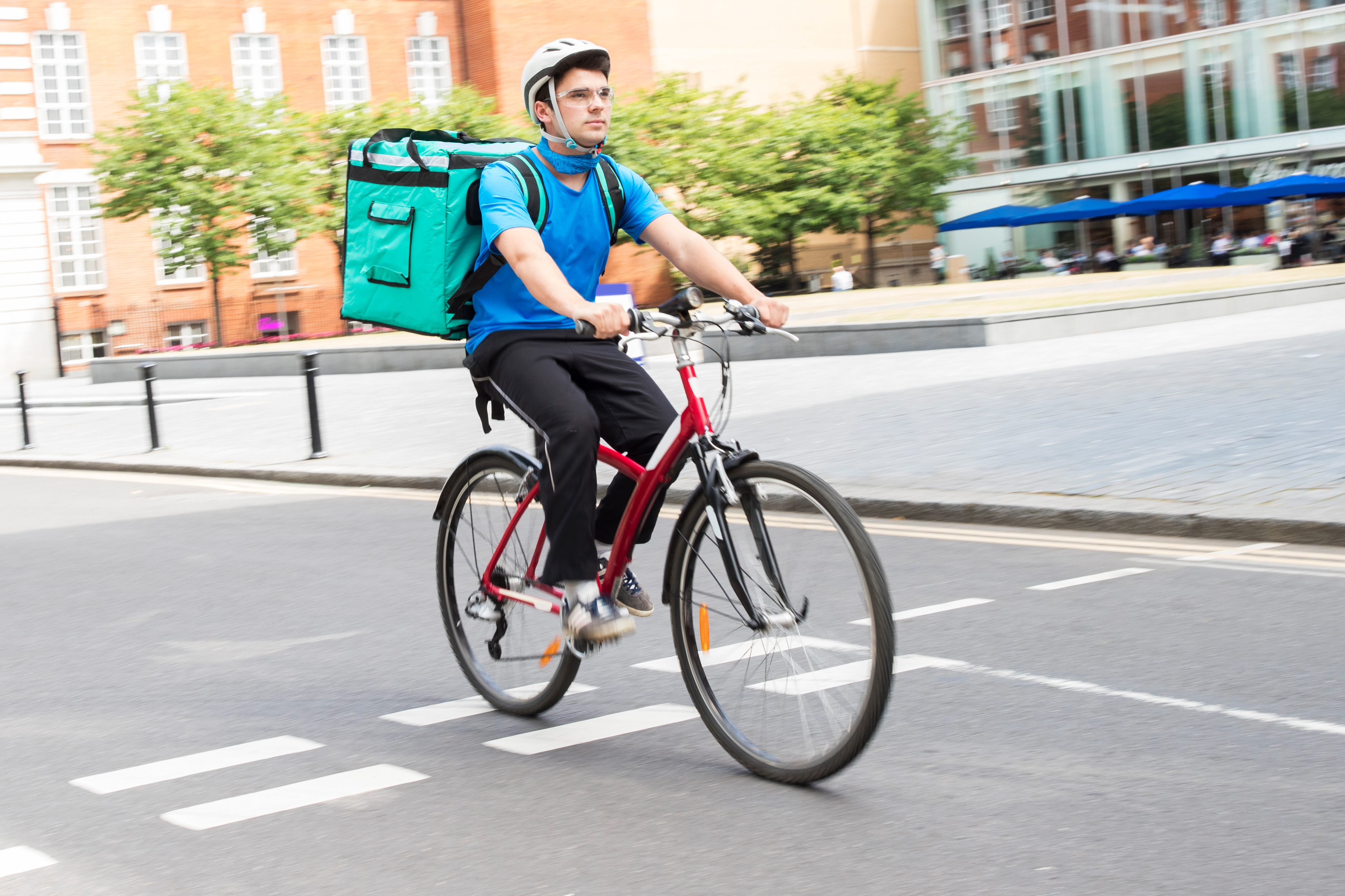 The Gig Economy: Courier On Bicycle Delivering Food In City